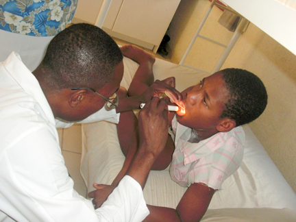 Dr Mardy examines a boy at our medical facility in Haiti