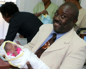 JHC Administrator, Nixon, with newborn - Jesus Healing Center - Love A Child